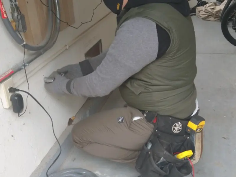 Electrician performing outlet wiring in a Oxford garage